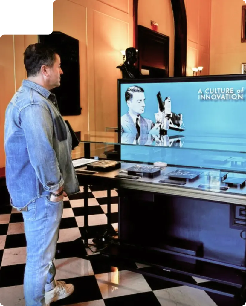 Serhan Museum – Ili Digital Dr Serhan Ili Standing in Front of a Digital Tv in an Innovation Museum